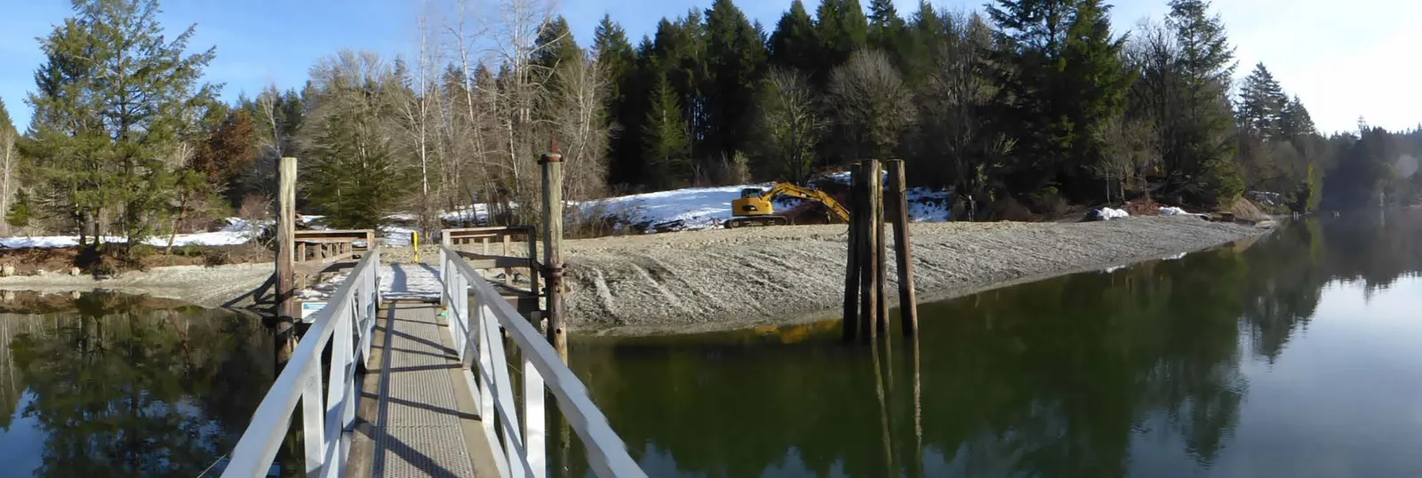 Wide view of the Tod Inlet Beach project showing barges with sediment and large conveyor machinery