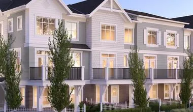 Wide-angle rendering of a townhouse development at dusk