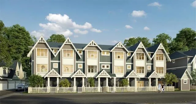 Front view of dark grey three-story townhouses with white window trim and gabled roofs