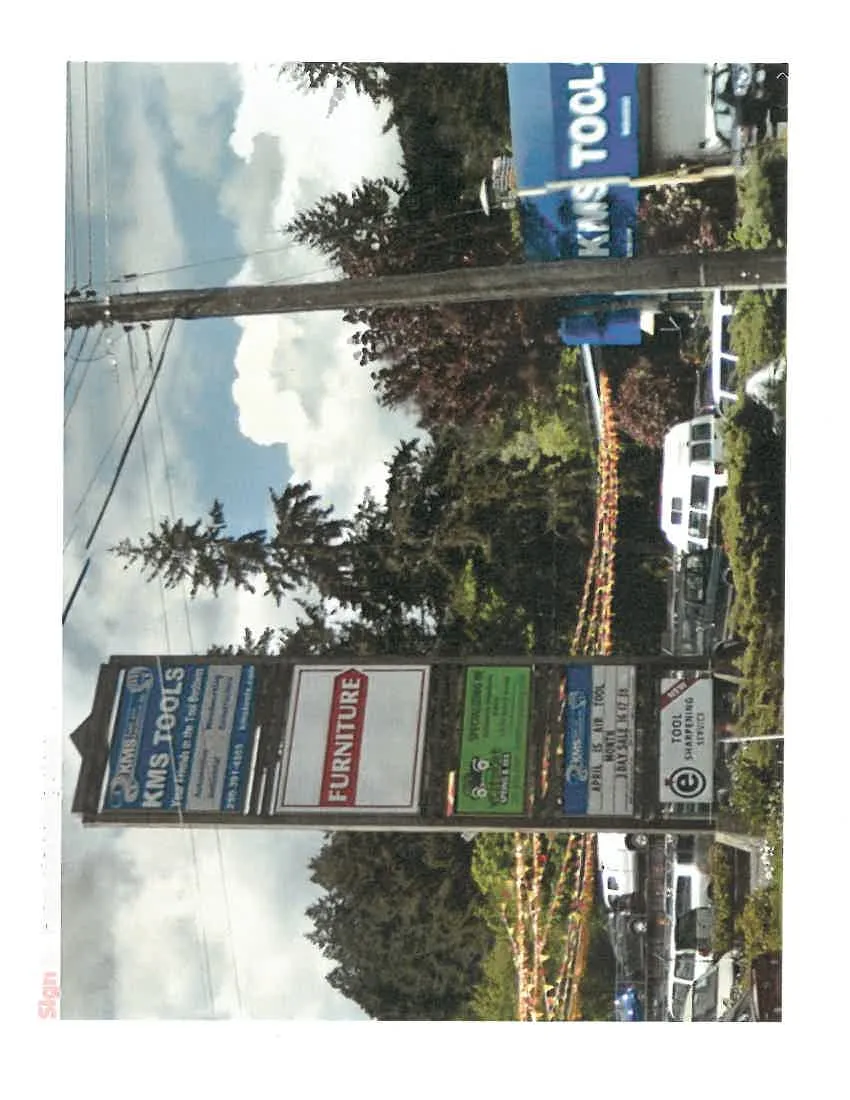 A multi-tenant pylon sign displaying advertisements for KMS TOOLS, FURNITURE, and WESTSHORE SPRING & 4X4.