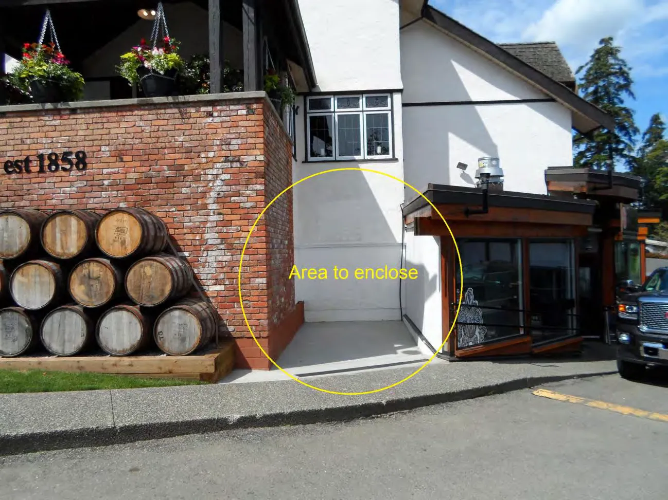 Photograph of the exterior of the Four Mile Brewpub showing the brick facade with "est 1858" and a yellow circle highlighting the "Area to enclose" for the proposed storage addition.