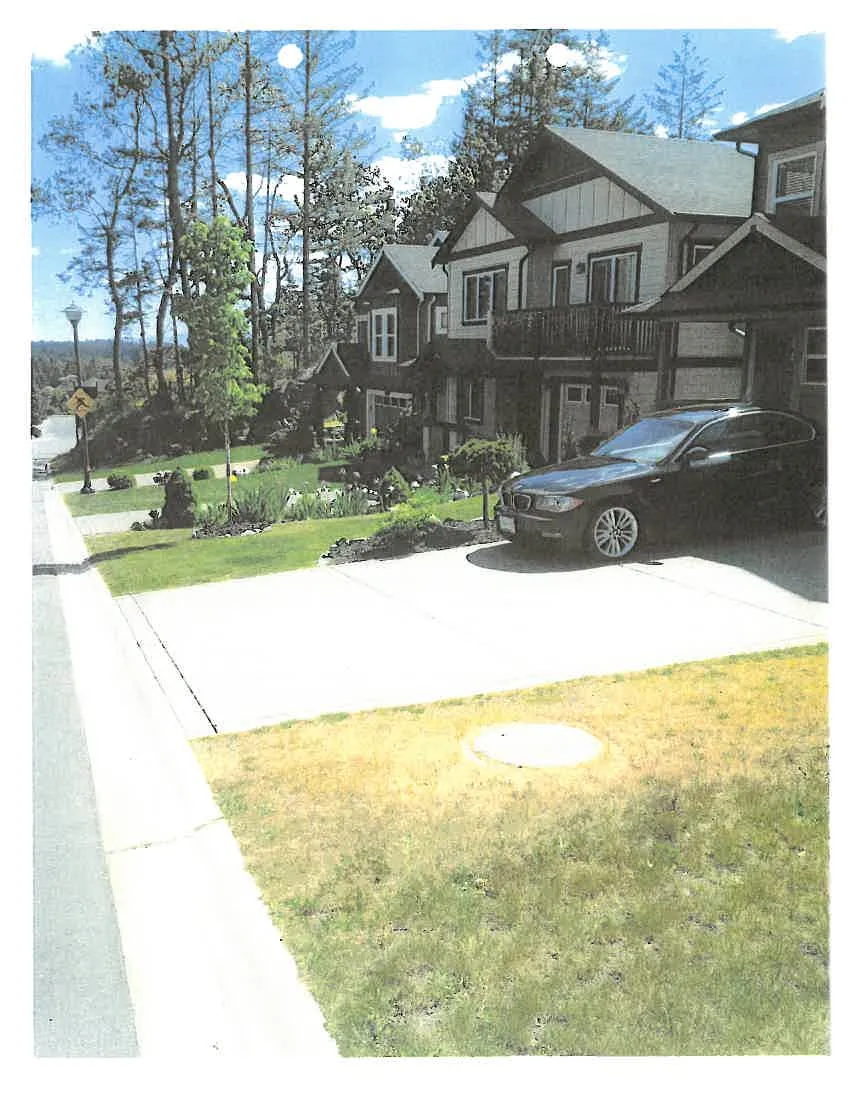 Photograph of houses in Phase 5 with a car parked in a driveway, illustrating the parking space result